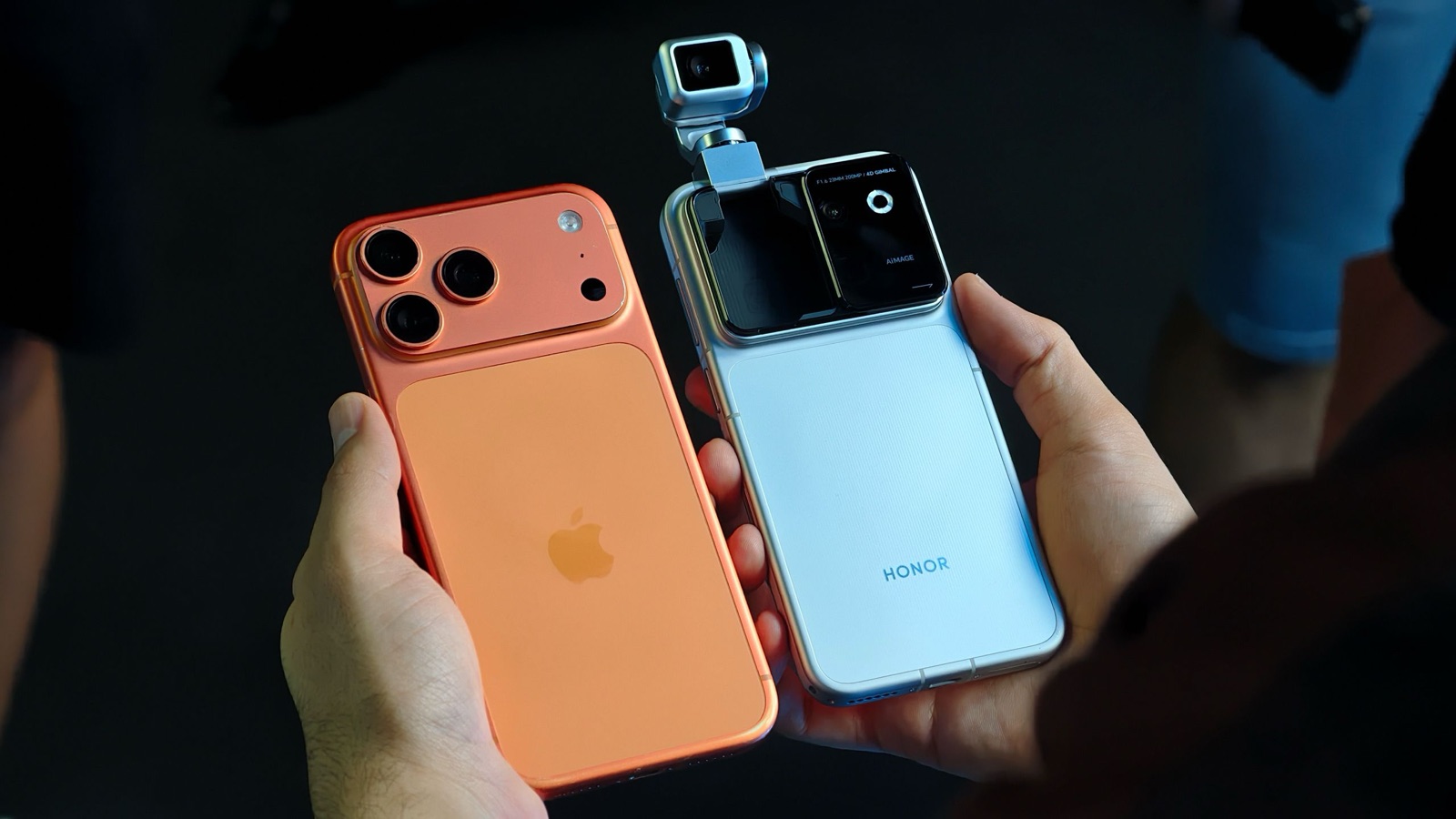 HONOR Robot Phone with raised gimbal held beside an iPhone 17 Pro Max